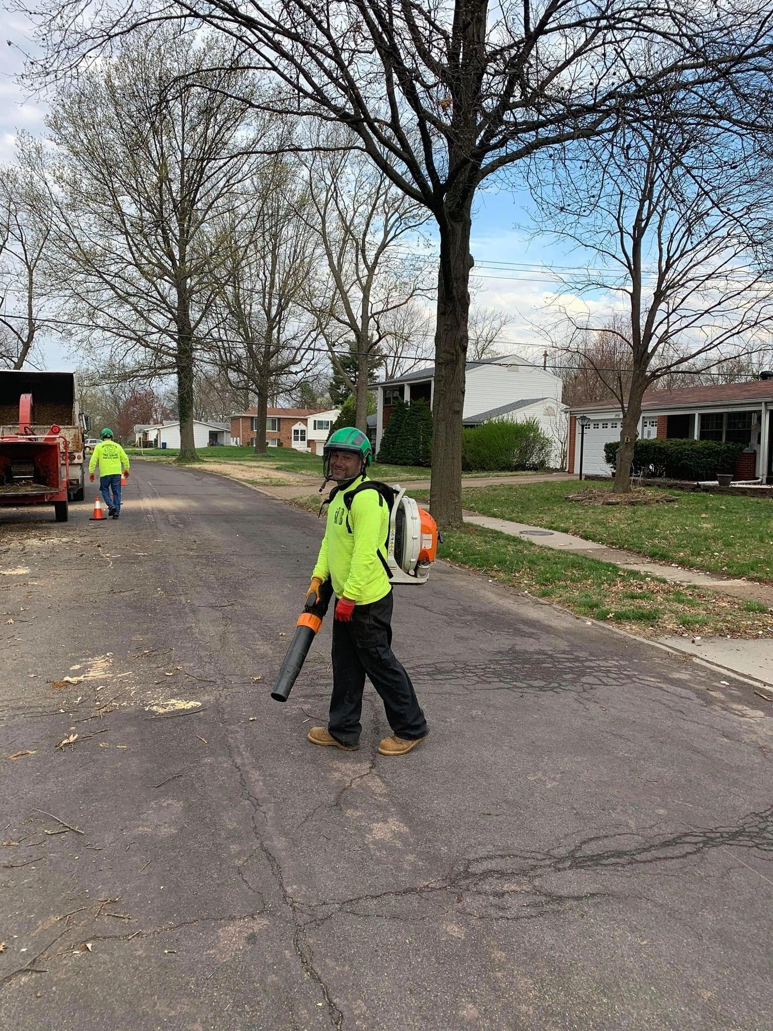 B. Woody's crew in hi-vis safety gear during cleanup following a large job — the site left clean